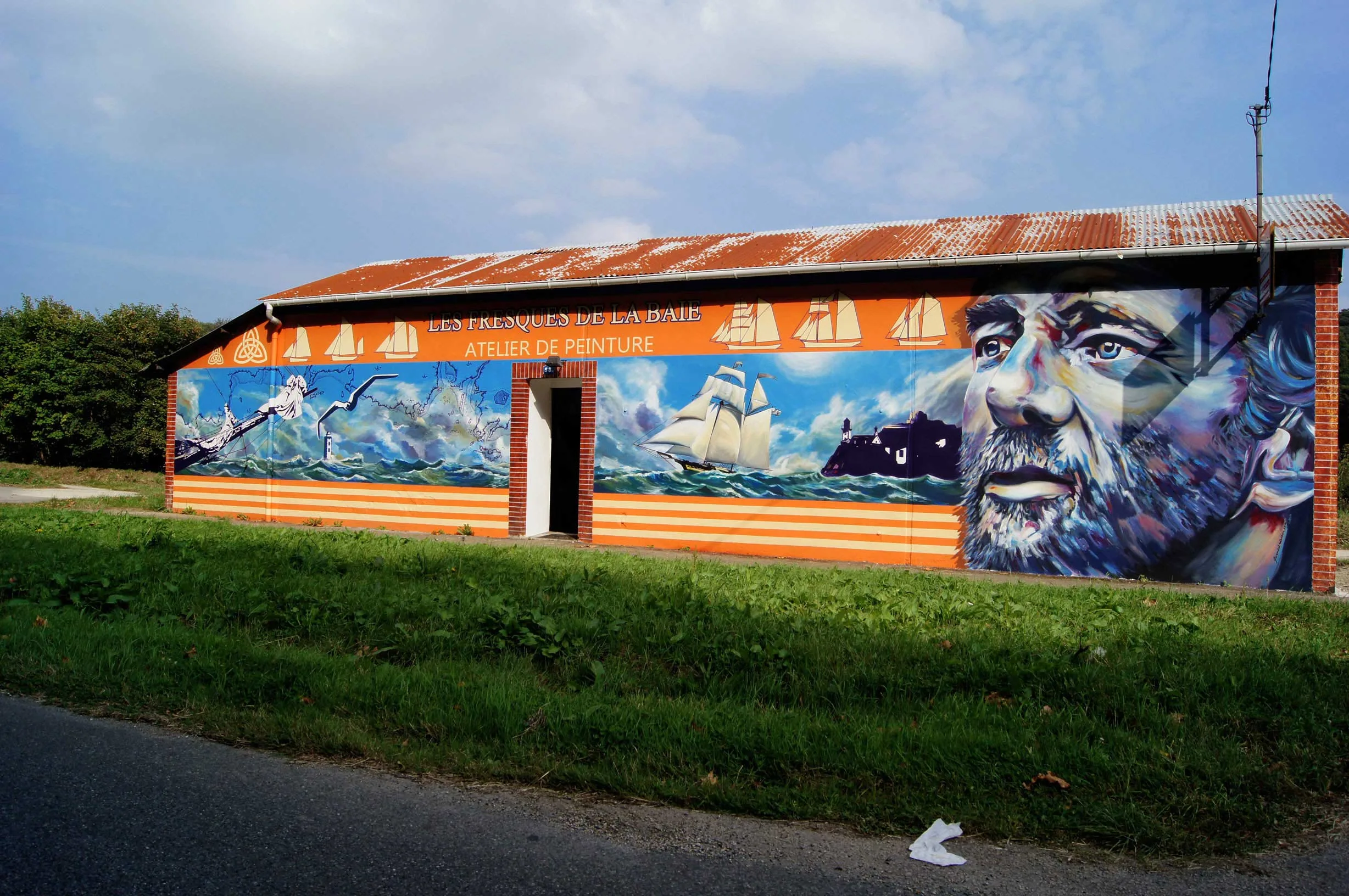 Façade d'atelier de muraliste peinte en street art, portrait du navigateur Éric Tabarly au port de Morlaix